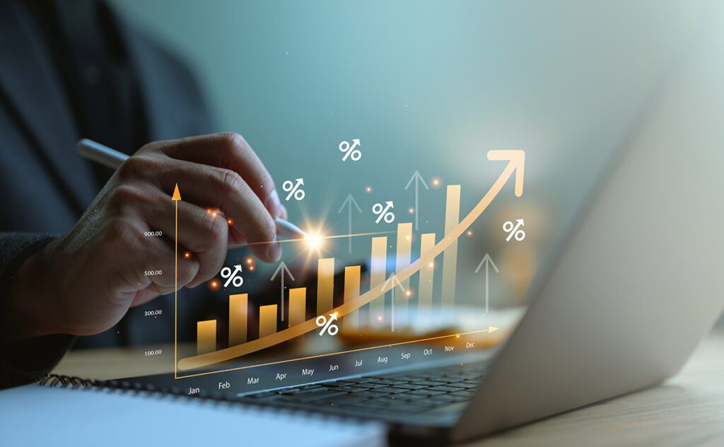 A rising graph overlaid on a businessman's laptop.